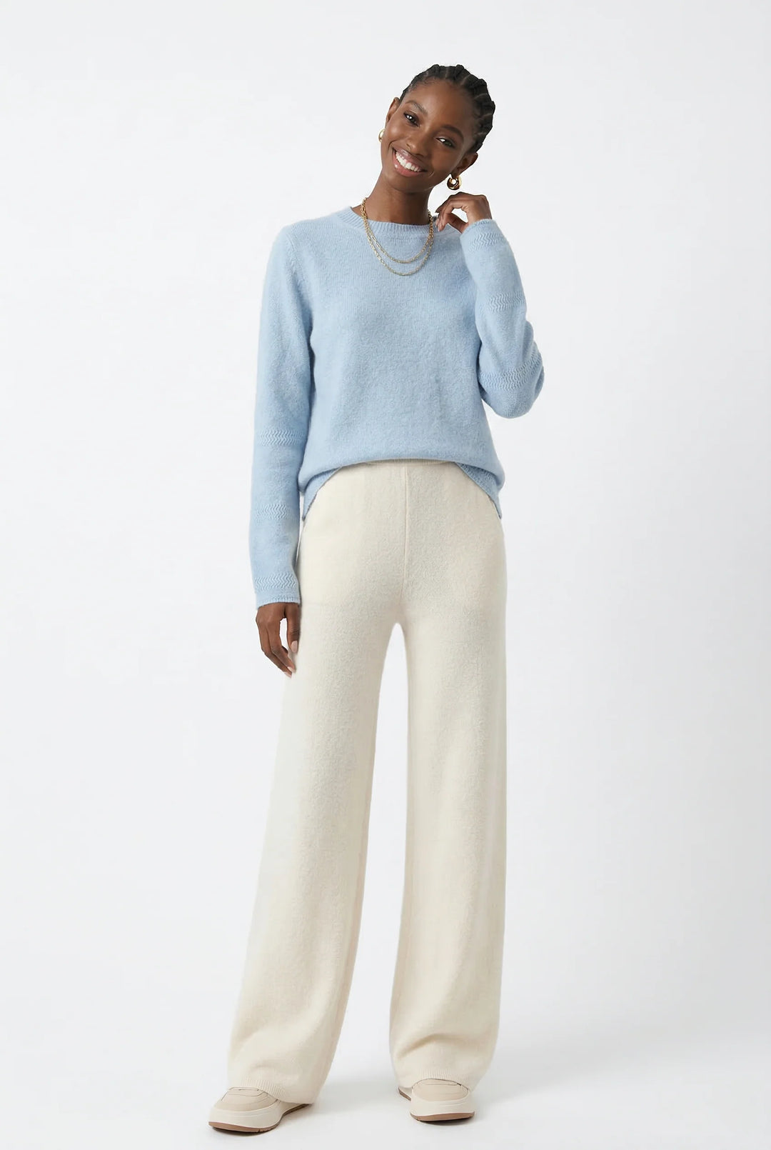 Side angle of woman in cream Merino Pants highlighting wide-leg silhouette and drape