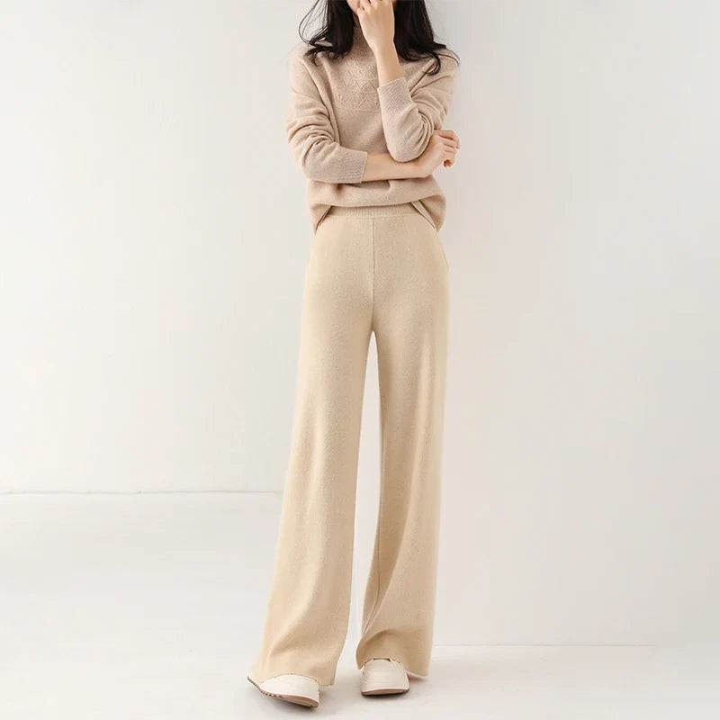 Woman wearing cream Merino Pants in casual setting with light blue knit jumper