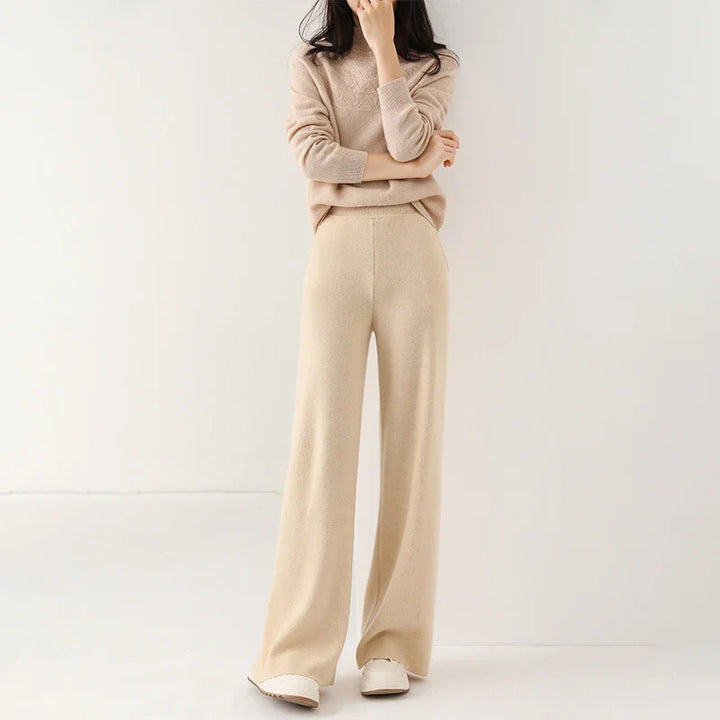 Woman wearing cream Merino Pants in casual setting with light blue knit jumper