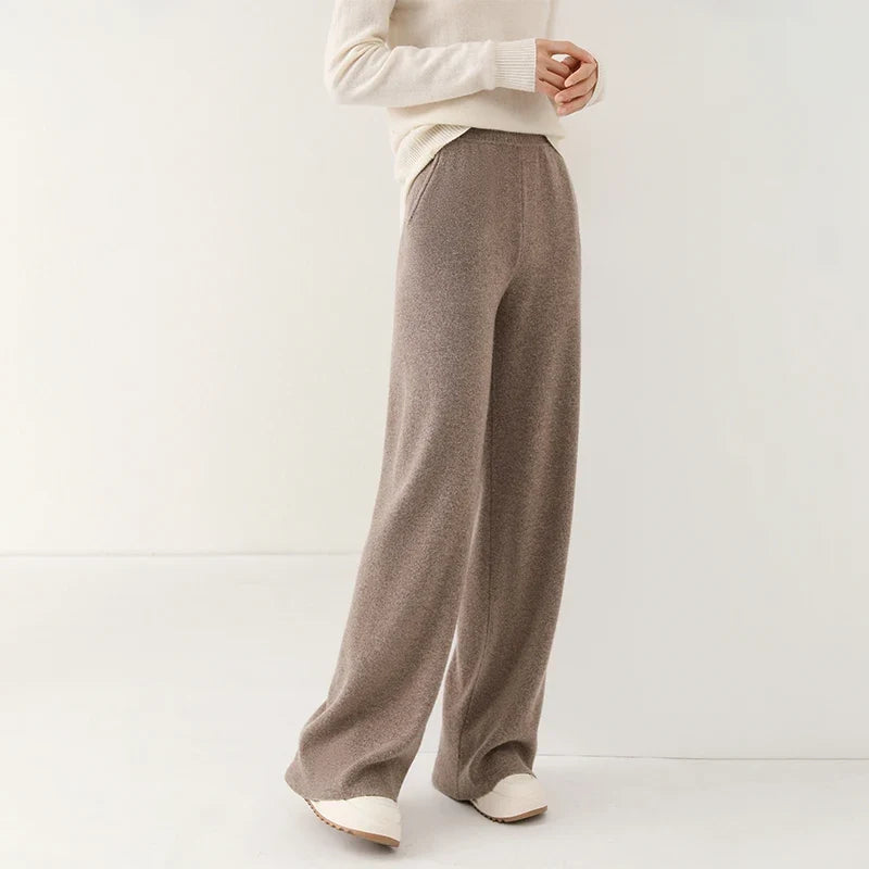 Side angle of woman wearing cream wide-leg Merino Pants with casual trainers