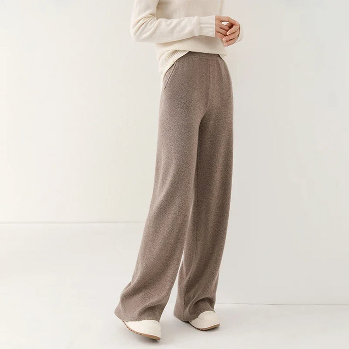 Side angle of woman wearing cream wide-leg Merino Pants with casual trainers