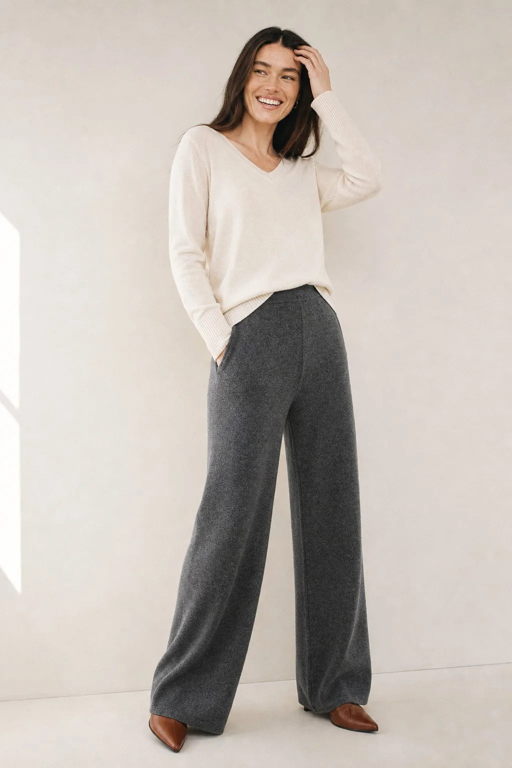 Back view of woman in cream wide-leg Merino Pants with high waist and relaxed fit