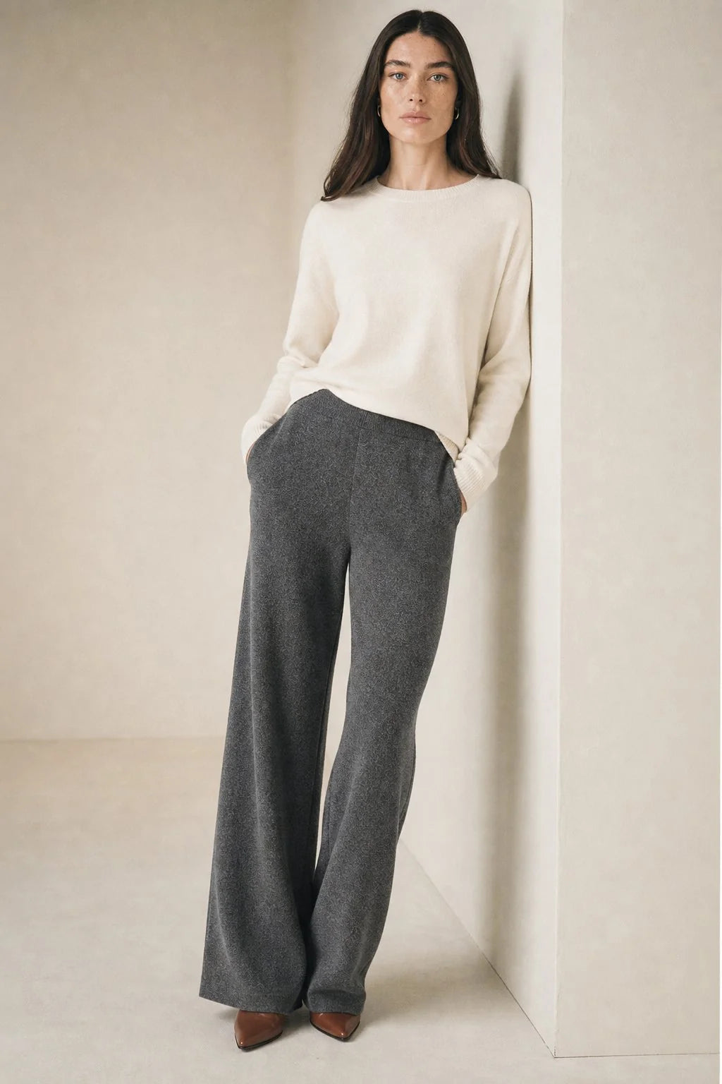 Woman standing in cream Merino Pants paired with light blue jumper for layered casual look