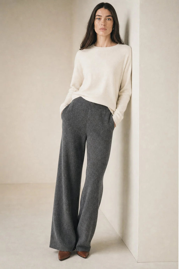 Woman standing in cream Merino Pants paired with light blue jumper for layered casual look