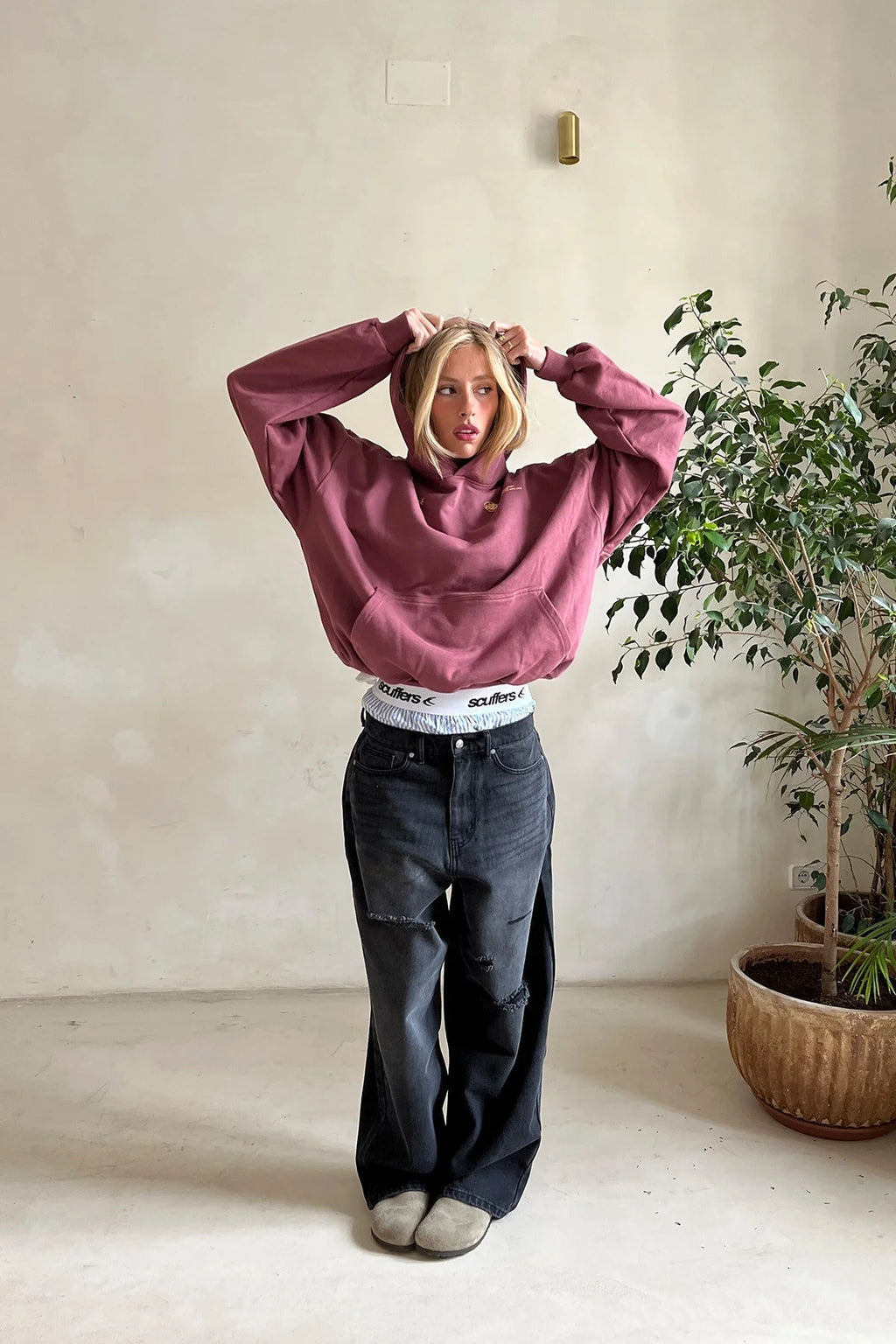Close-up of women's oversized hoodie showing kangaroo pocket and fleece interior construction