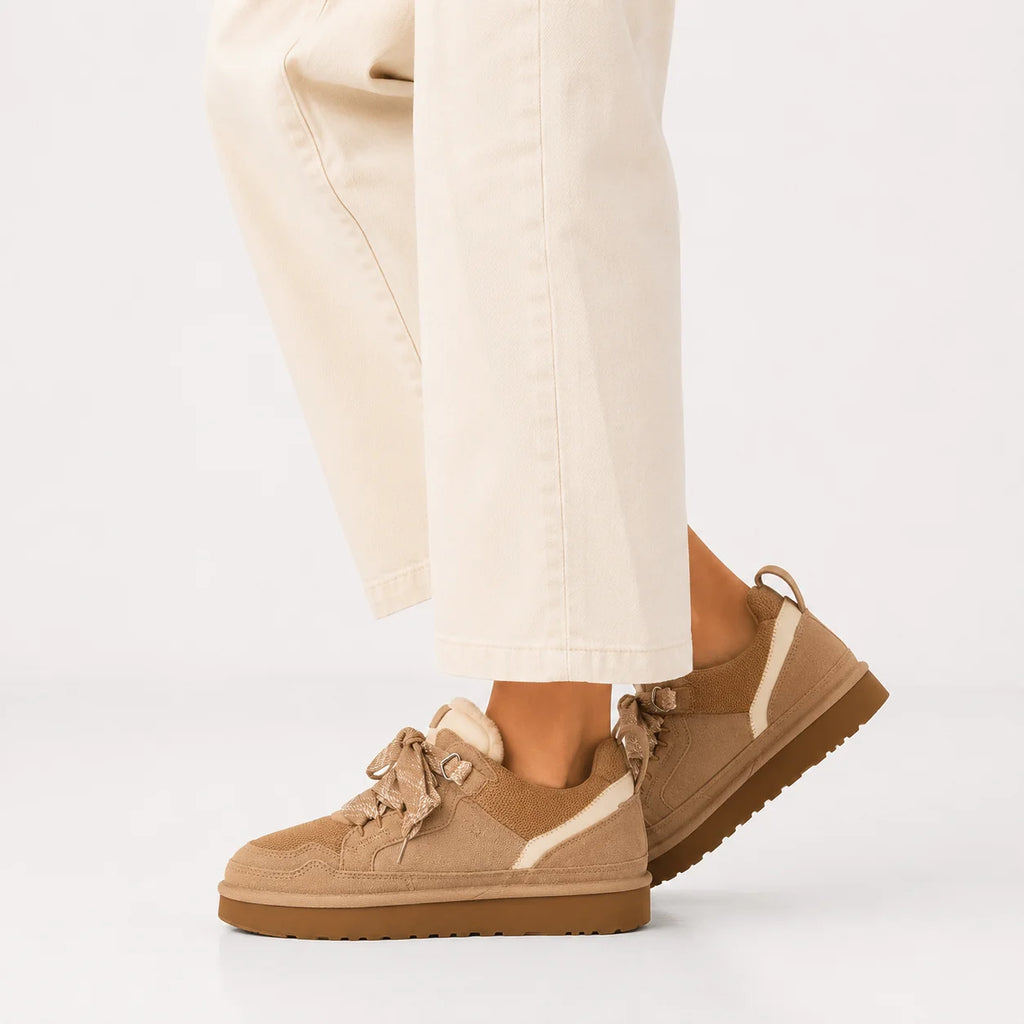 Women's platform trainers in beige with fleece lining and chunky sole, styled with cream trousers