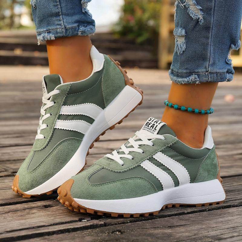 Side profile of women's retro running trainers showing layered construction and stripe detail