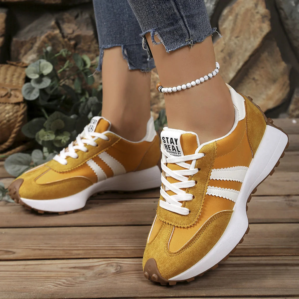 Detail shot of women's retro trainers highlighting suede texture and contrast stitching
