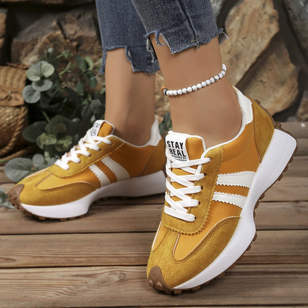 Detail shot of women's retro trainers highlighting suede texture and contrast stitching
