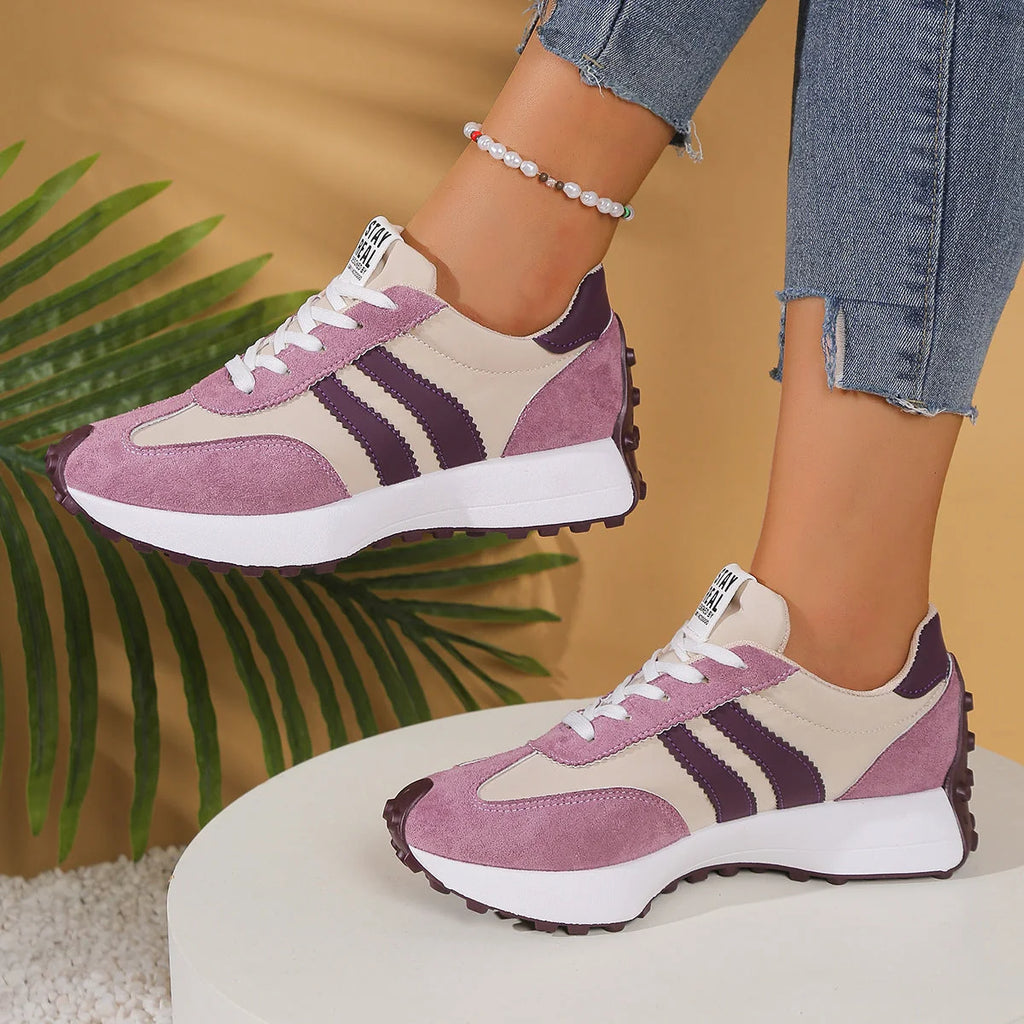 Women's burgundy retro running trainers with chunky sole and sporty design on wooden deck