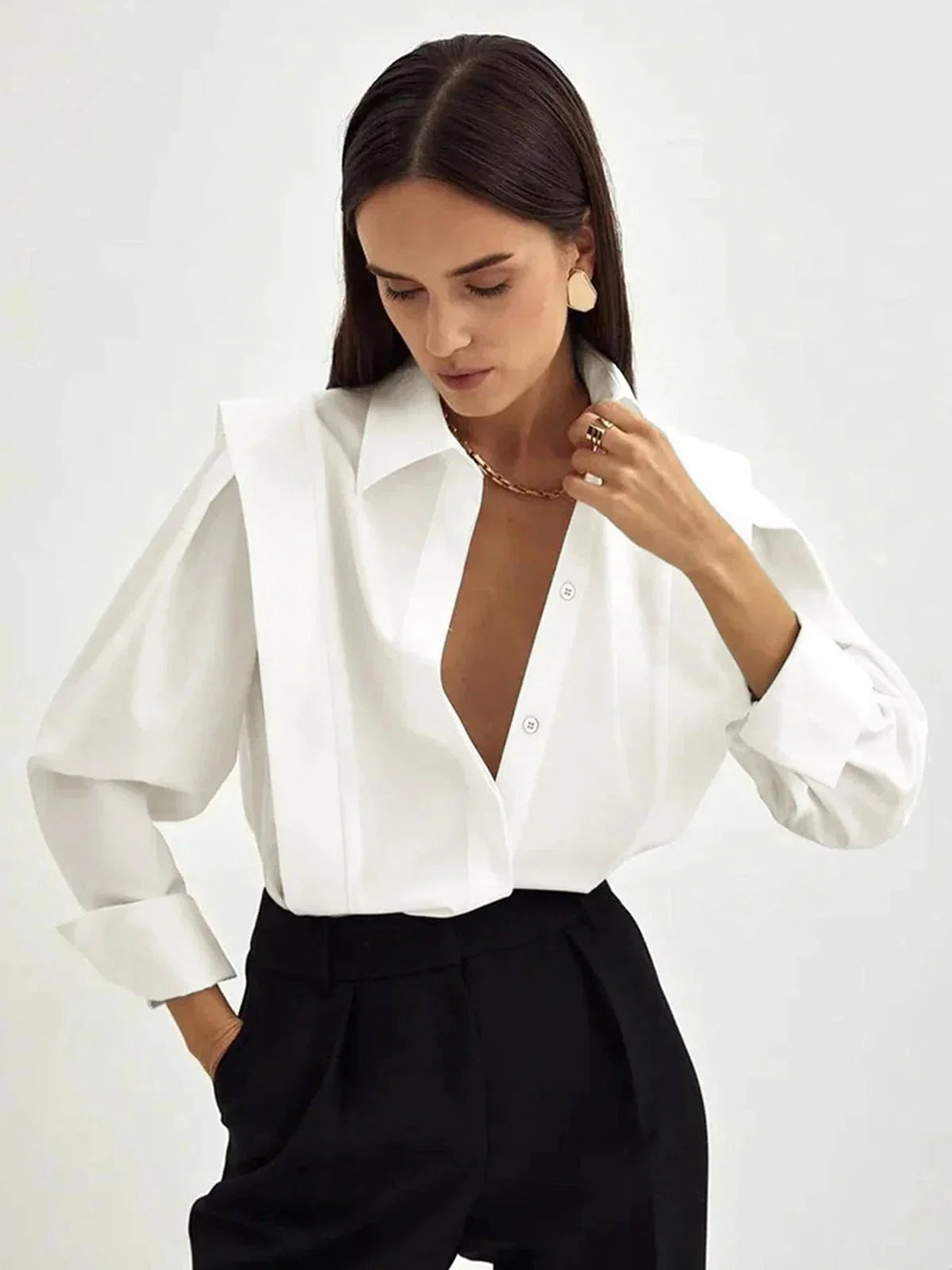 Close-up of structured shoulder detail with pleating on women's white button-up shirt