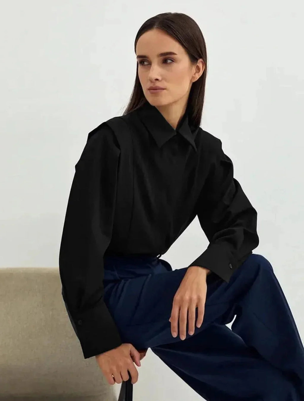 Full-length view of women's white shirt with structured shoulders paired with black trousers