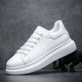 Men's chunky sole trainers in white with lace-up front and platform sole on dark background
