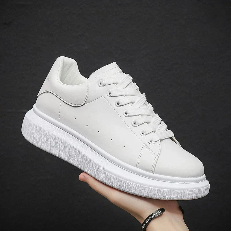 Detail shot of white chunky trainers showing perforated side accents and clean finish