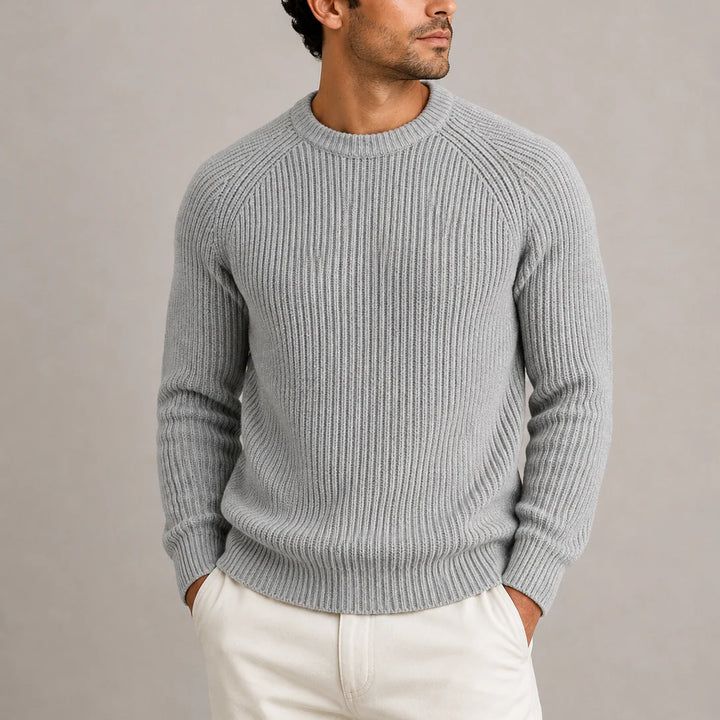 Men's ribbed knit jumper in grey with crew neck and raglan sleeves worn with cream trousers