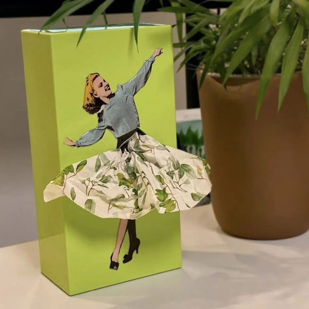 Yellow retro tissue box holder showing three-dimensional skirt detail with vintage illustration on bright background