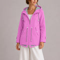 Women's hooded raincoat with zip-front closure and striped lining detail, shown in orchid pink