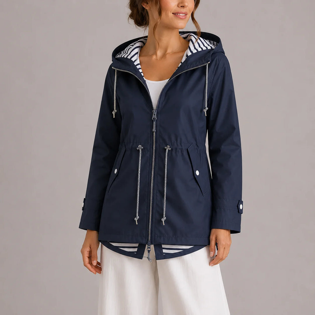 Detail of cuff tab with button fastening on women's raincoat sleeve