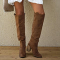 Close-up of women's knee high boots showing structured shaft and pull-on design with block heel.
