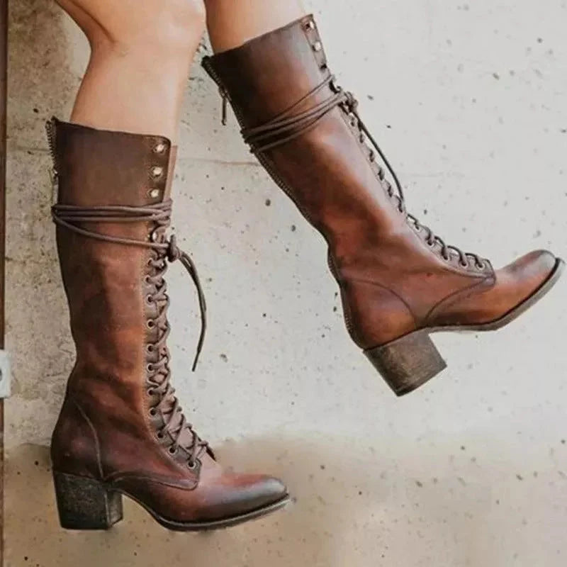 Side profile of women's knee-high boots with decorative studs and wrap-around lace detail