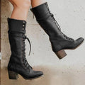Detail shot of block heel and pointed toe on women's knee-high lace-up boots