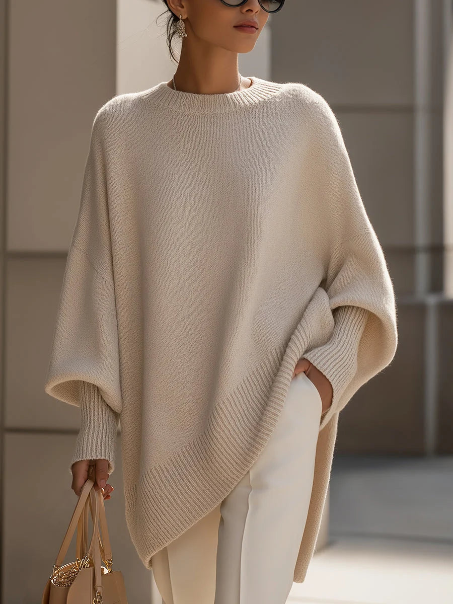 Women's oversized knit jumper in beige with drop shoulders and asymmetric hem styled with cream trousers