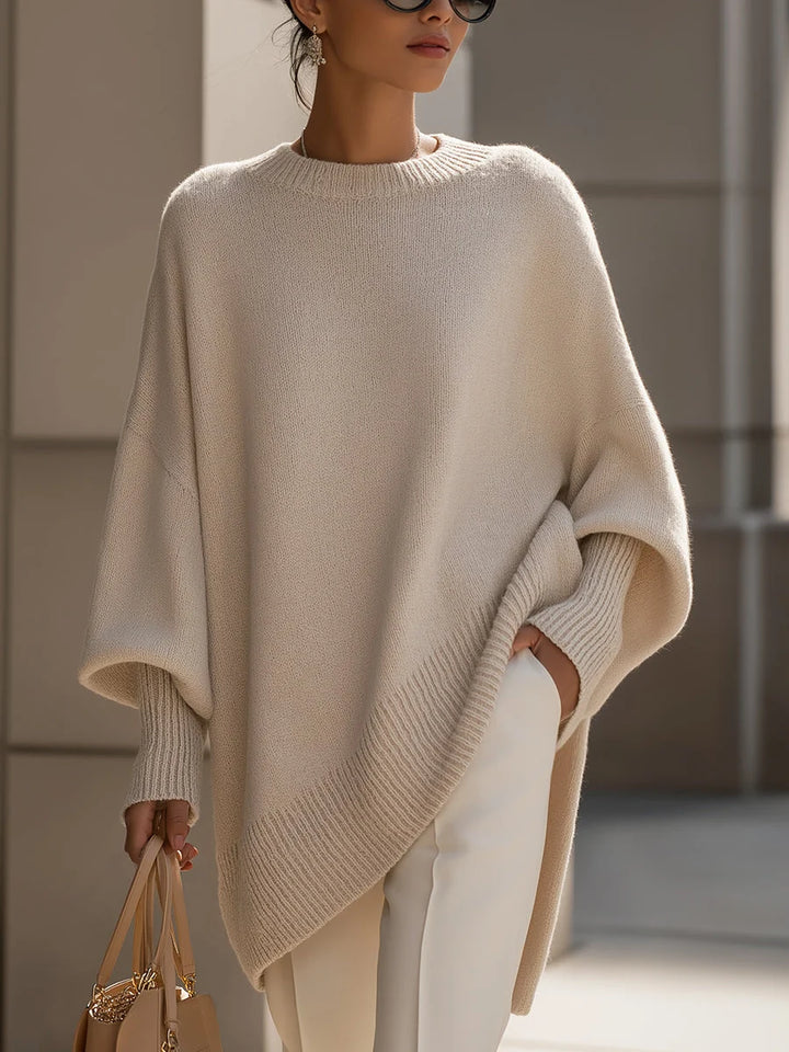 Women's oversized knit jumper in beige with drop shoulders and asymmetric hem styled with cream trousers