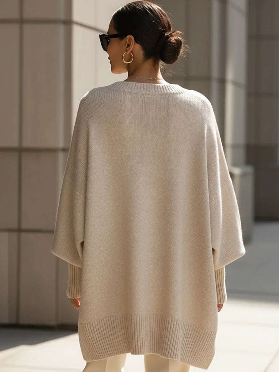 Model wearing beige oversized knit jumper with drop shoulders over fitted cream trousers