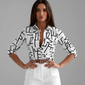 Women's printed shirt with bold black graphic pattern on white base and classic collar