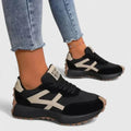Women's retro trainers with contrast stripe detail and chunky sole worn with cropped jeans