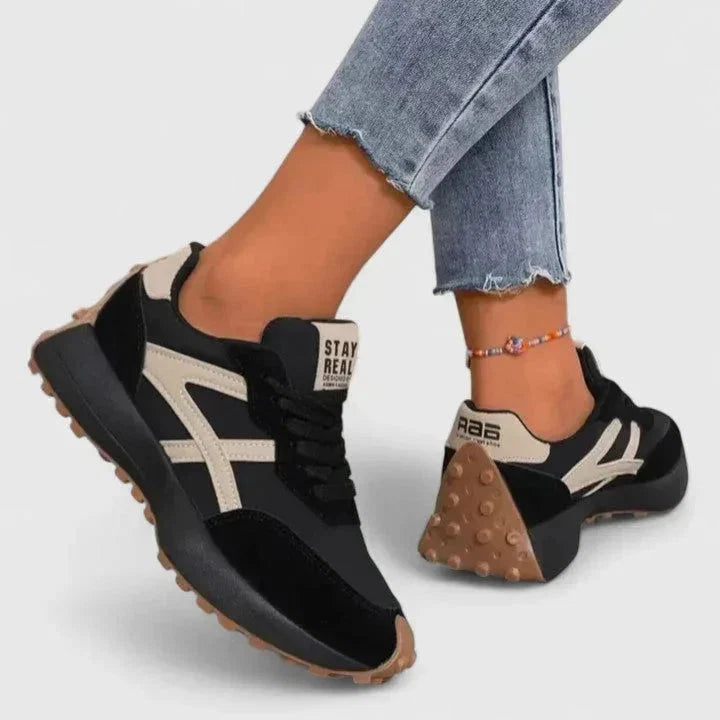 Close-up of women's retro trainers showing lace-up closure and side stripe design