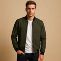 Men's bomber jacket in olive green with ribbed collar, cuffs, and full-zip closure worn over white t-shirt