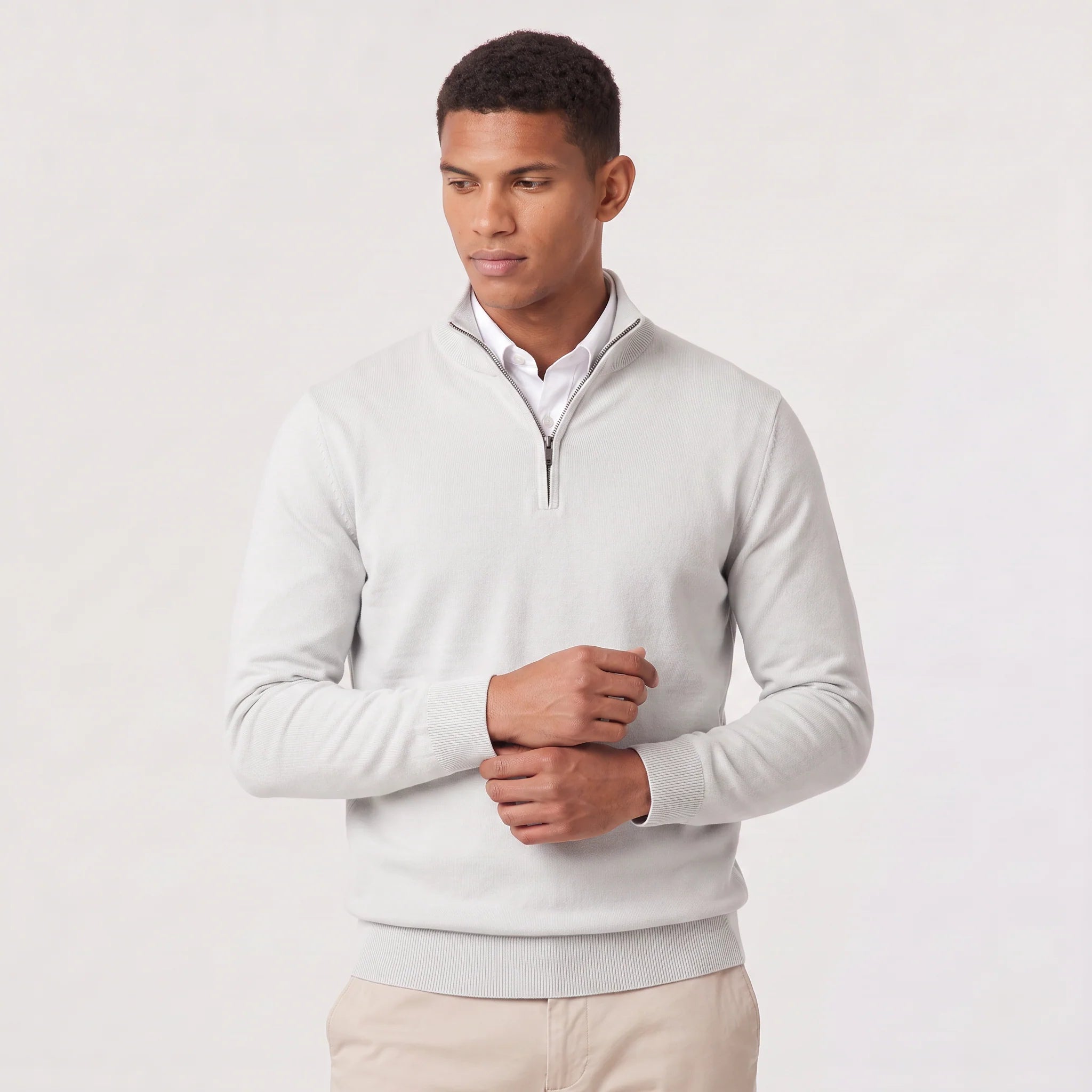 Flat lay of men's quarter-zip knit jumper showing stand collar and ribbed cuffs detail
