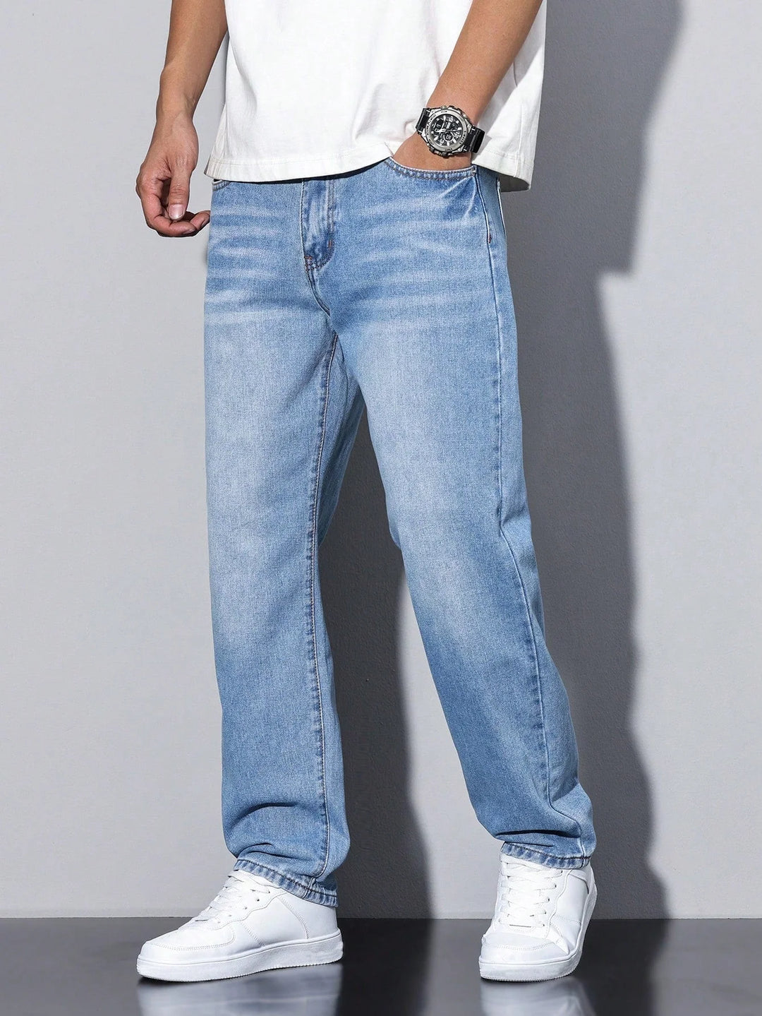 Men's grey straight leg jeans paired with white trainers for casual styling