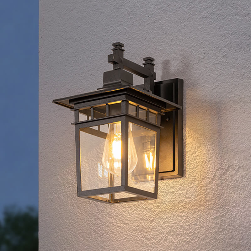 Close-up view of outdoor lantern wall light showing E27 bulb through clear glass panels