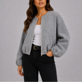 Grey cropped bomber jacket with zip front and elasticated cuffs worn over white top and black trousers