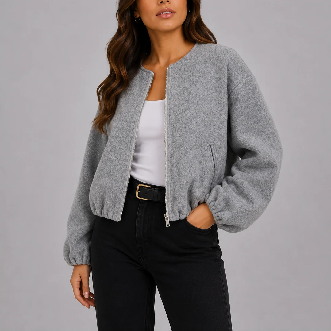 Grey cropped bomber jacket with zip front and elasticated cuffs worn over white top and black trousers