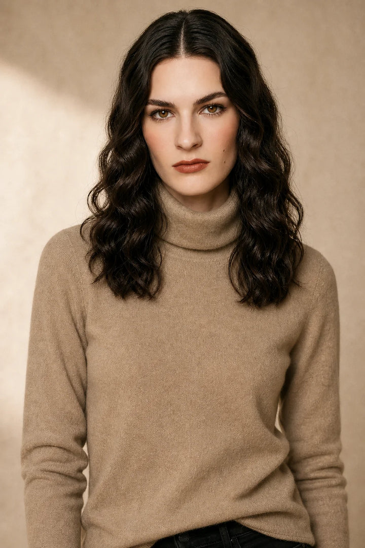 Woman wearing a taupe cashmere turtleneck in a minimalist setting, demonstrating the timeless silhouette and roll neck