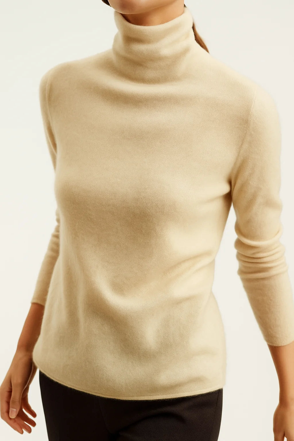 Side profile of a model in a cashmere turtleneck showing the close fit at the neck and relaxed body