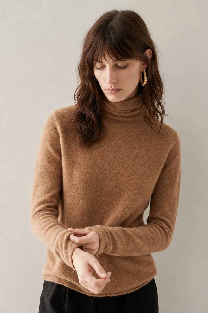 Detail of the turtleneck collar and shoulder seam on a women's cashmere jumper in a neutral beige shade