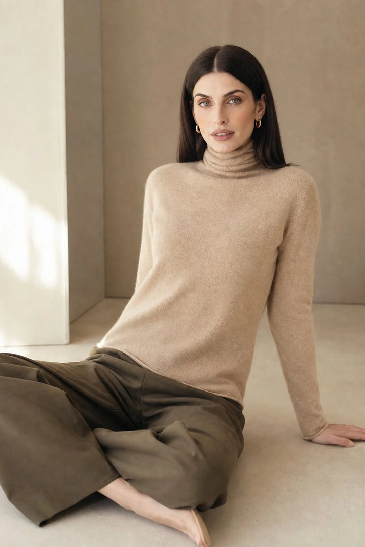 Full-length view of a woman in a taupe cashmere turtleneck paired with matching trousers for a coordinated look