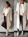 Women's double-breasted longline coat in beige with notched lapels and tailored silhouette, styled over cable knit jumper