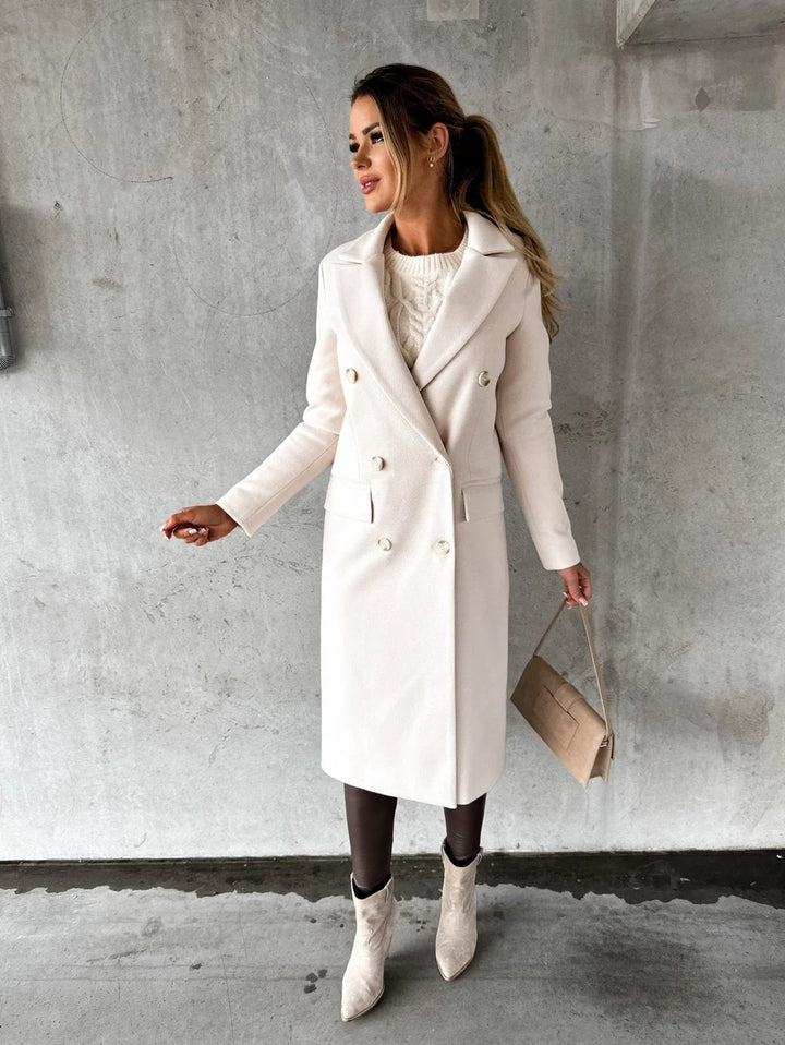 Close-up view of women's structured longline coat showing double-breasted button closure and smooth woven fabric finish
