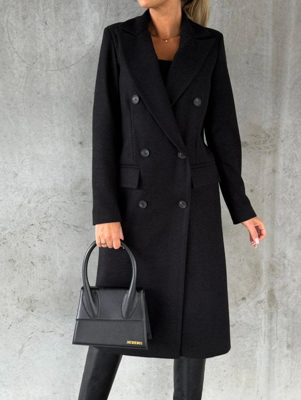 Full-length view of women's double-breasted coat showing mid-thigh length and tailored silhouette with ankle boots