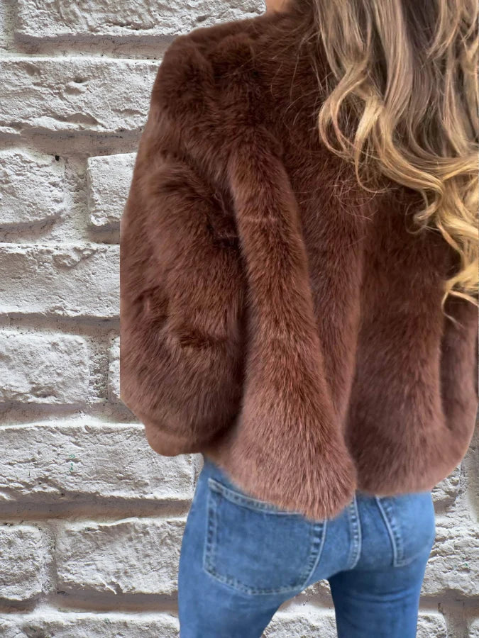 Back view of women's cropped faux fur bomber jacket with ribbed hem detail