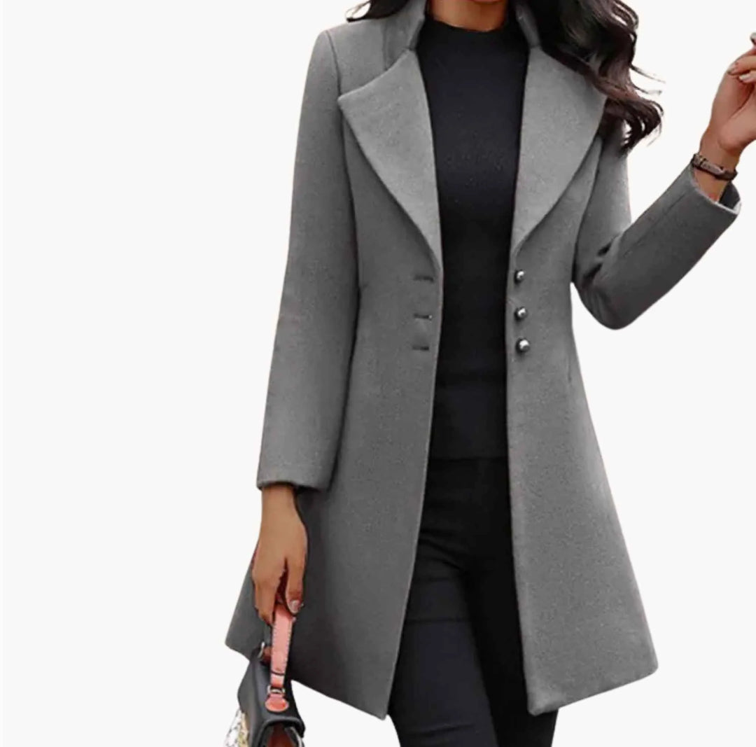 Women's long tailored coat in grey with wide lapels and button detail, fitted silhouette, knee-length hem.