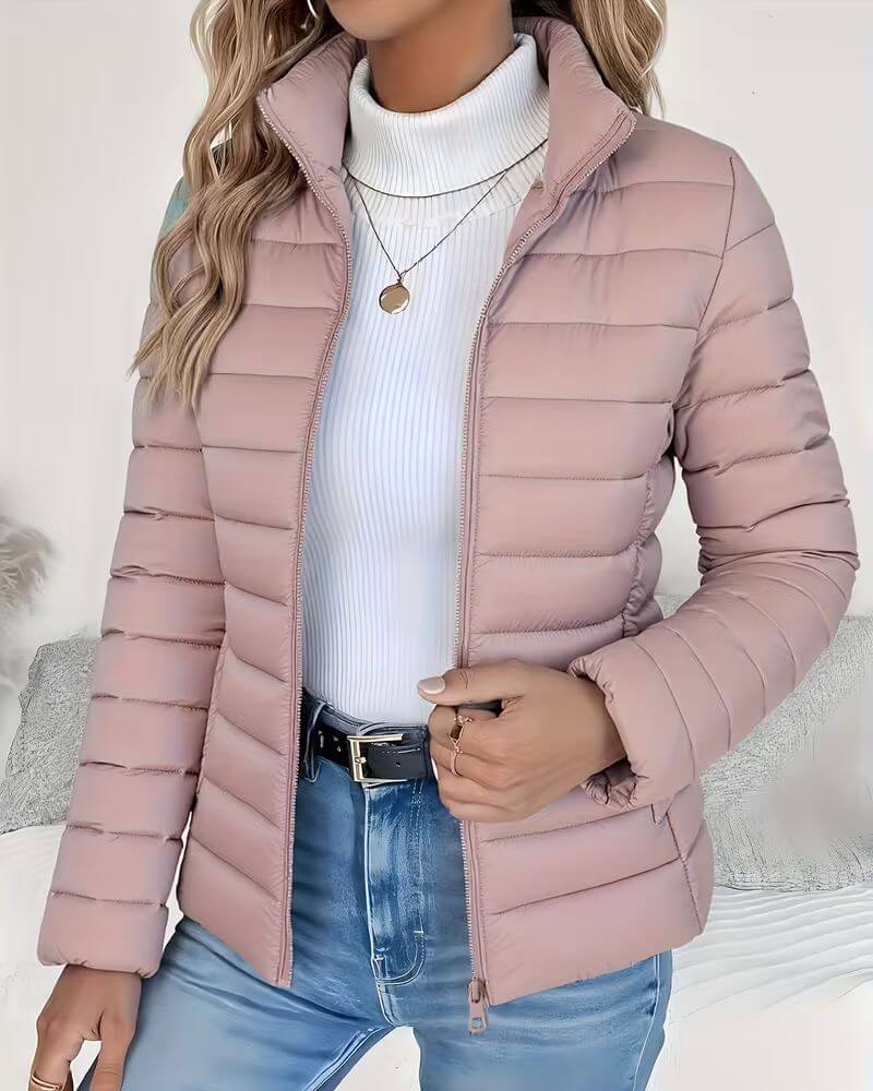 Women's cropped puffer jacket with tailored silhouette and hip pockets, layered over white knitwear