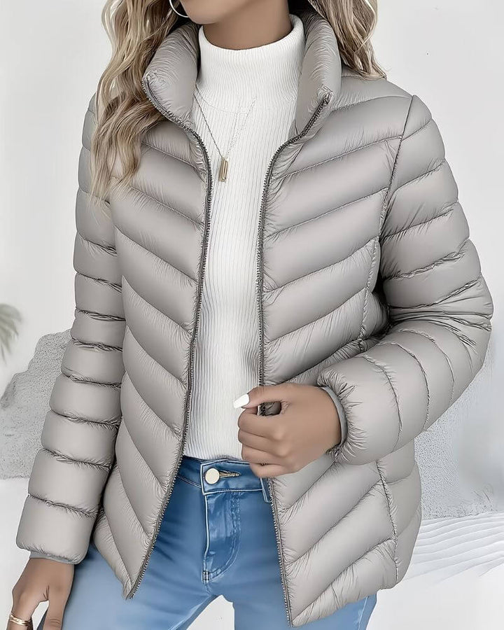 Women's stand collar puffer jacket with full-length zip, ideal for layering over casual winter outfits