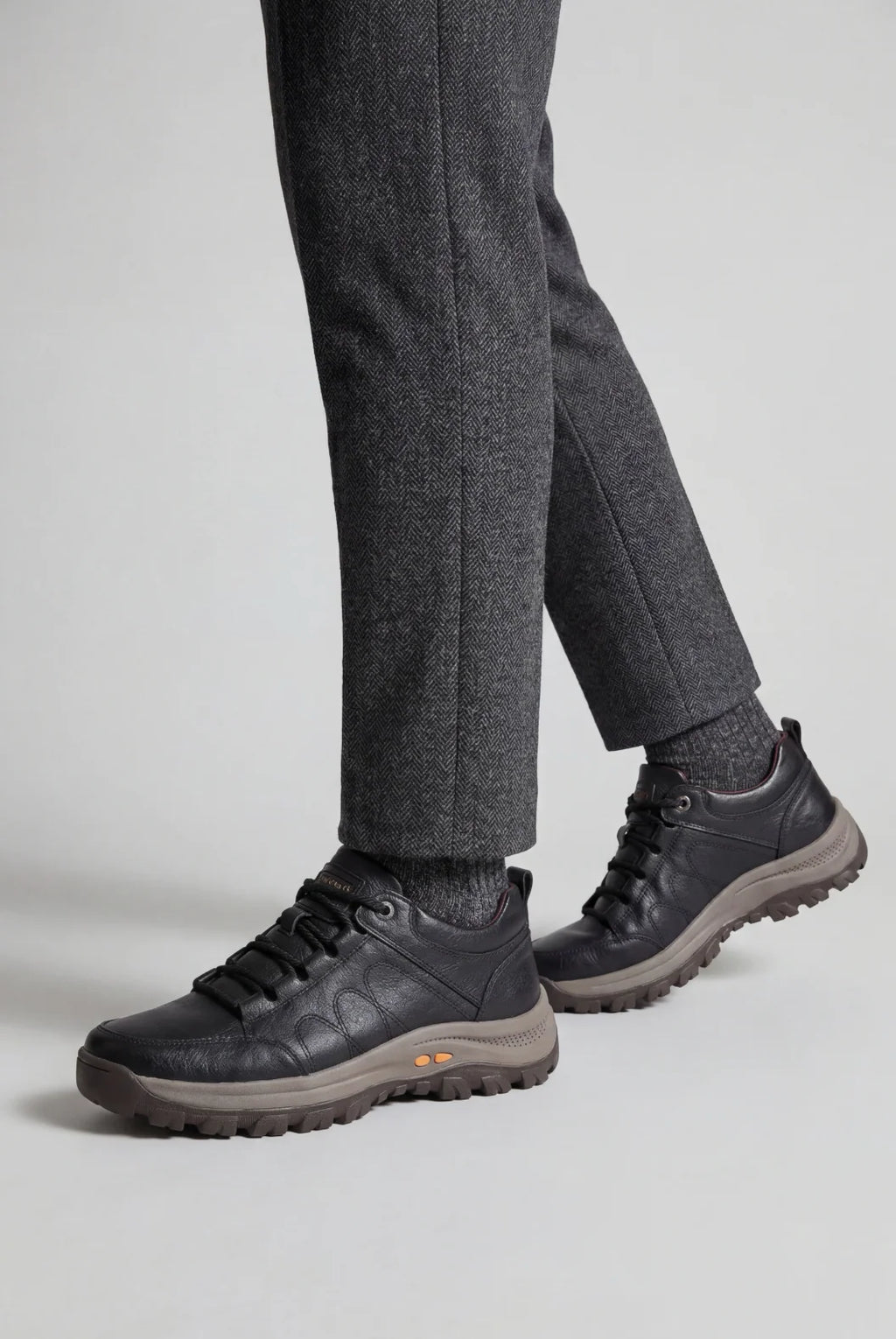 Side view of men's black walking shoes showing structured panelling and supportive midsole design