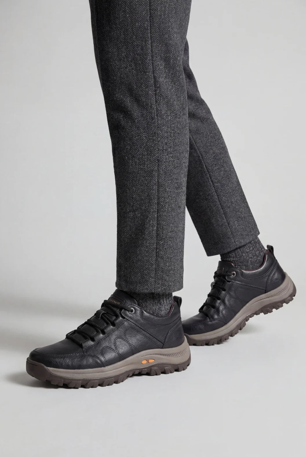 Side view of men's black walking shoes showing structured panelling and supportive midsole design